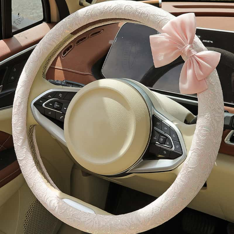 Blush pink lace steering wheel cover with bow installed on car steering wheel