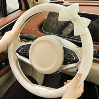 Cream lace steering wheel cover with bow installed in car interior